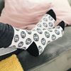Socks with Psi Chi Seal pattern with sweatpants on a sofa